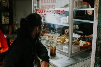 a woman standing in front of a counter filled with food