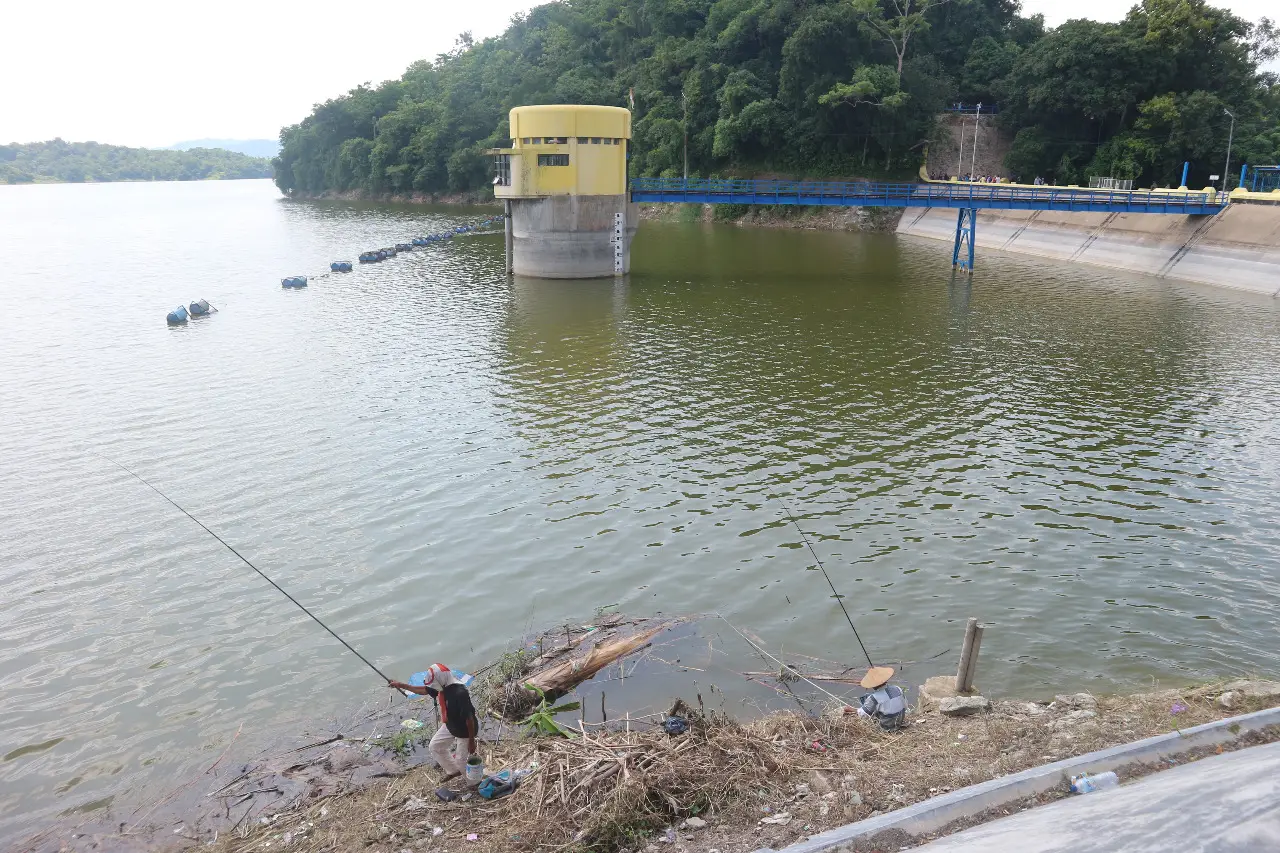 Potret Wisata Waduk Pacal Bojonegoro, beberapa orang sedang memancing.