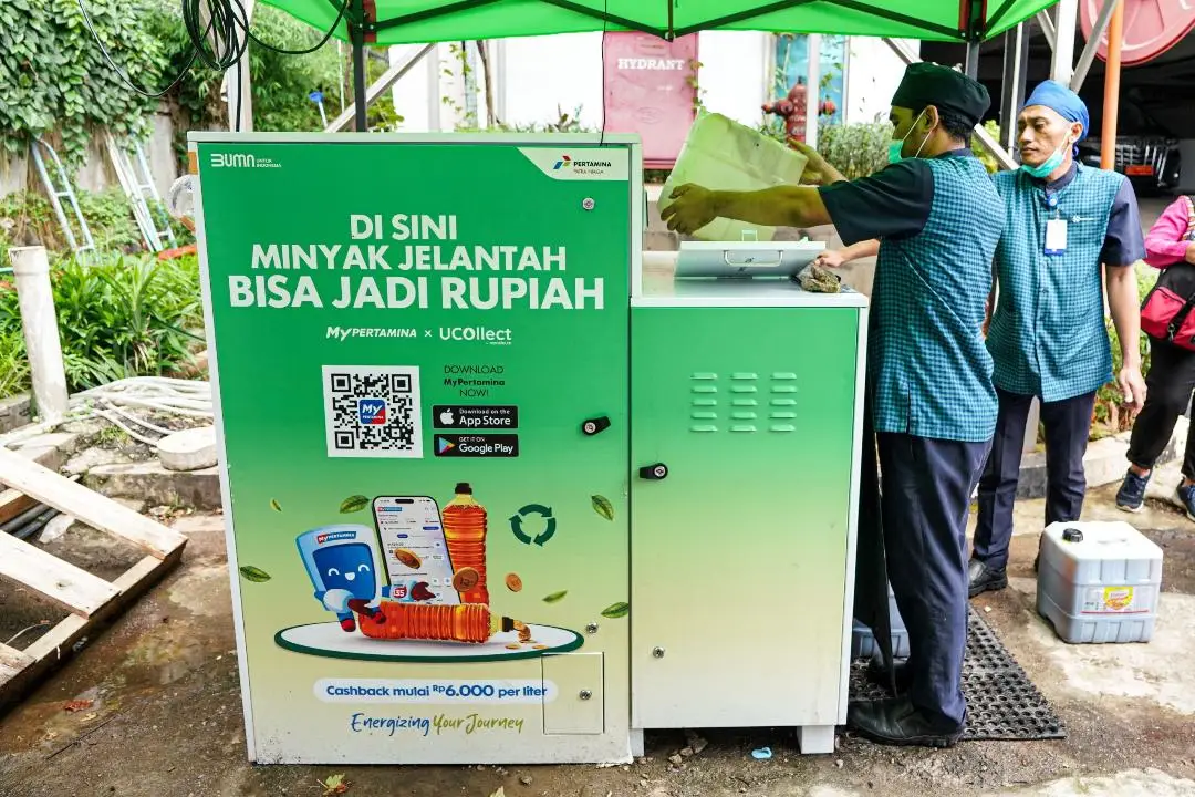 Kios penukaran minyak jelantah Pertamina. Seseorang sedang menukarkan minyak dari jirigen ke box penukaran.