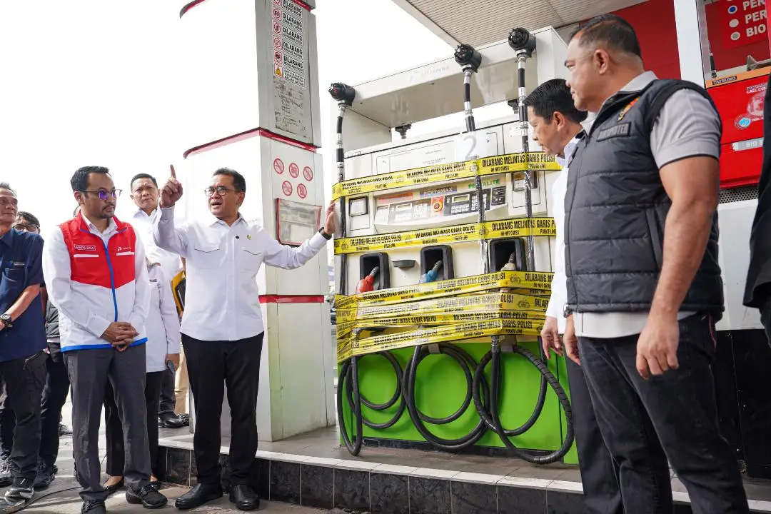 Menteri Perdagangan Budi Santoso, bersama Direktur Tipidter Bareskrim Polri Brigjen Polisi Nunung Syaifuddin dan Pelaksana Tugas (PLT) Direktur Utama Pertamina Patra Niaga Mars Ega Legowo Putra, berfoto di depan dispenser SPBU yang disegel menggunakan garis polisi.